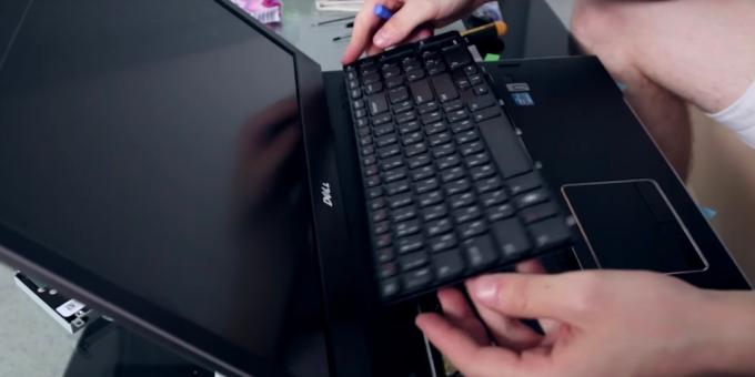 Fejtse közvetítő kilincsek kerülete a billentyűzet, és óvatosan emelje a tiszta laptop